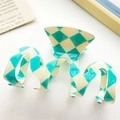 Blue and cream checkered wavy hair claw clip with glossy finish in a lifestyle setting - Large Wave Checkerboard Style / Blue & White Checkerboard