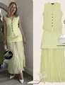 Detail of light green knit vest and pleated maxi skirt set with button-down front - Green Vest And Skirt Outfit