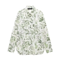 Dettaglio di camicia a fiori con bottoni, base bianca, foglie verdi ed etichetta del marchio - Top