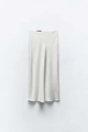 Detailed close-up of cream satin midi skirt showing smooth silk texture and clean waistline - White