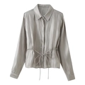 Detail of silver grey satin shirt showing lustrous silk-like fabric and waist tie - Gray