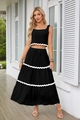 Dettaglio del crop top senza maniche e gonna lunga a balze con bordo a onde bianco - S / Nero