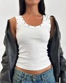 Detailed view of white ribbed tank top with metal eyelets under a black leather jacket - S / White
