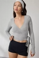 Detail of grey wrap-style V-neck long sleeve top with waist ties and thumbhole cuffs - S / Gray
