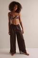 Detail view of brown satin wide-leg pants with delicate eyelash lace trim at the hem - S / Brown