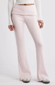 Dettaglio dei pantaloni a zampa in maglia rosa con un elegante design a vita risvoltata - S / Rosa