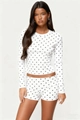 Detailed macro shot of white fabric with black polka dots on a long-sleeve top and shorts - White