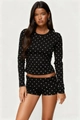 Detail of slim-fit polka dot pajama set featuring long-sleeve top and shorts - Black