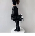Detalle de pantalones anchos negros con rayas laterales y cintura elástica con cordón - S / Negro