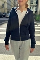 Detail of navy zip-up hoodie with drawstring hood and kangaroo pockets in street setting - Dark Blue