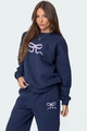 Detail of navy blue sweatshirt and joggers set with pink ribbon bow prints on fabric - S / Dark Blue