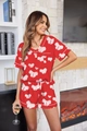 Detalle de pijama de satén rojo con estampado de lazos y ribete blanco en manga y bolsillo - Rojo sandía