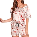 Detalle del conjunto de pijama de satén rosa con estampado de corazones y vivos negros - Corazón