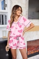 Vista detallada del pijama de satén rosa con estampado de lazos y ribete negro elegante - Patchwork floral