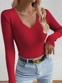 Detail of red ribbed knit top featuring a scalloped V-neckline and textured long sleeves - Red