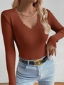 Close-up of rust red V-neck knit sweater with scalloped edges and ribbed texture - Caramel color