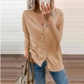 Detailed close-up of camel V-neck cardigan with dark buttons and ribbed knit texture - Camel