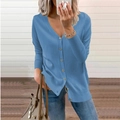 Detail of blue V-neck cardigan featuring ribbed cuffs and a classic button-down closure - Blue