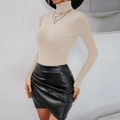 Detail of beige ribbed turtleneck knit sweater and black pleated leather mini skirt - S / Tops / Apricot