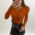 Detail of orange ribbed knit sweater with V-neck button design and black leather skirt - Caramel color
