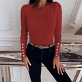 Detail view of the sleeve cuffs with gold decorative buttons on the ribbed knit sweater - Brick Red