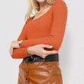 Detail of orange ribbed knit sweater fabric showing vertical texture and wide neckline - Orange