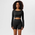 Detail of black seamless yoga set featuring thumbhole cuffs and high waist shorts - Black Long Sleeve And Bra And Shorts Style