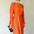 Detailed view of bright orange pleated long sleeve dress with waist tie and textured fabric - S / Orange