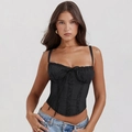 Vista detallada de las costuras de encaje negro en un top estilo corsé con lazo decorativo - S / Tops / Negro