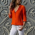 Detalle de camisa naranja vibrante con joyas doradas y pantalones blancos finos - S / Naranja Brillante