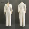 Detail of white deep V-neck jumpsuit featuring puff sleeves and belted high waist - S / White