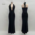 Detail of elegant black deep V-neck halter dress with ruching and open back design - S / Black
