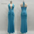 Detail of peacock blue evening gown showing deep V-neckline and elegant ruched waist texture - Teal