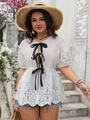 Dettaglio del top in pizzo bianco con fiocchi di raso nero e ricami traforati eleganti - 1XL / Bianco