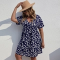 Vue détaillée du col en V et du motif de marguerites blanches sur la robe d'été bleu marine - Bleu marine