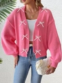 Détail du cardigan en maille rose avec des nœuds blancs et des poignets côtelés - S / Rose Rouge