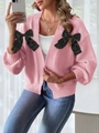 Detail of pink knitted cardigan featuring elegant black bows and ribbed texture - S / Tops / Pink
