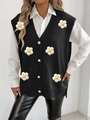 Detail of knitted black vest featuring 3D floral embroidery and large pearl buttons - One Size / Black