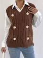 Detailaufnahme der Strickweste mit Zopfmuster und weißen Gänseblümchen-Applikationen - Kaffeebraun