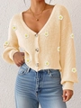 Nahaufnahme der beige Strickjacke mit 3D-Gänseblümchen-Applikationen und Bernstein-Knöpfen - S / Oberteile / Aprikose