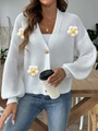 Detailed close-up of 3D knit daisies and marble button on white v-neck cardigan sweater - S / White (4 Large Flowers)