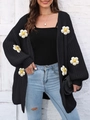 Gros plan du cardigan en maille noire avec appliques florales 3D blanches et textures - Taille unique / Noir
