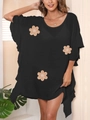 Dettaglio del copricostume nero ampio con toppe floreali beige e trama morbida - Nero