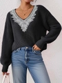 Dettaglio ricamo in pizzo bianco su maglione nero con scollo a V e silhouette morbida - S / Nero