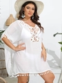 Detail of white crochet beach cover-up featuring fringe tassels and hollow knit patterns - White