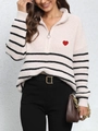 Close-up of striped knit sweater with half-zip collar and red heart embroidery detail - One Size / Apricot
