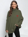 Close-up of the red heart patch detail on a green oversized turtleneck knit sweater - One Size / Army Green