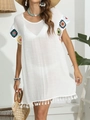 Close-up of bohemian white beach cover-up featuring colorful crochet sleeve and fringe detail - One Size / White