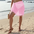 Pink sheer beach sarong featuring tassel trim detail and tie-up waist in a seaside setting - One Size / Bottoms / Pink