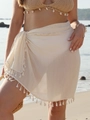 Detail of off-white beach sarong with fringe trim and cotton-linen texture on a model - One Size / Bottoms / Apricot